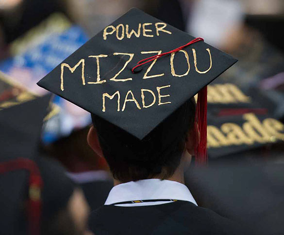 Student wearing mortarboard with "Power Mizzou Made" painted on it